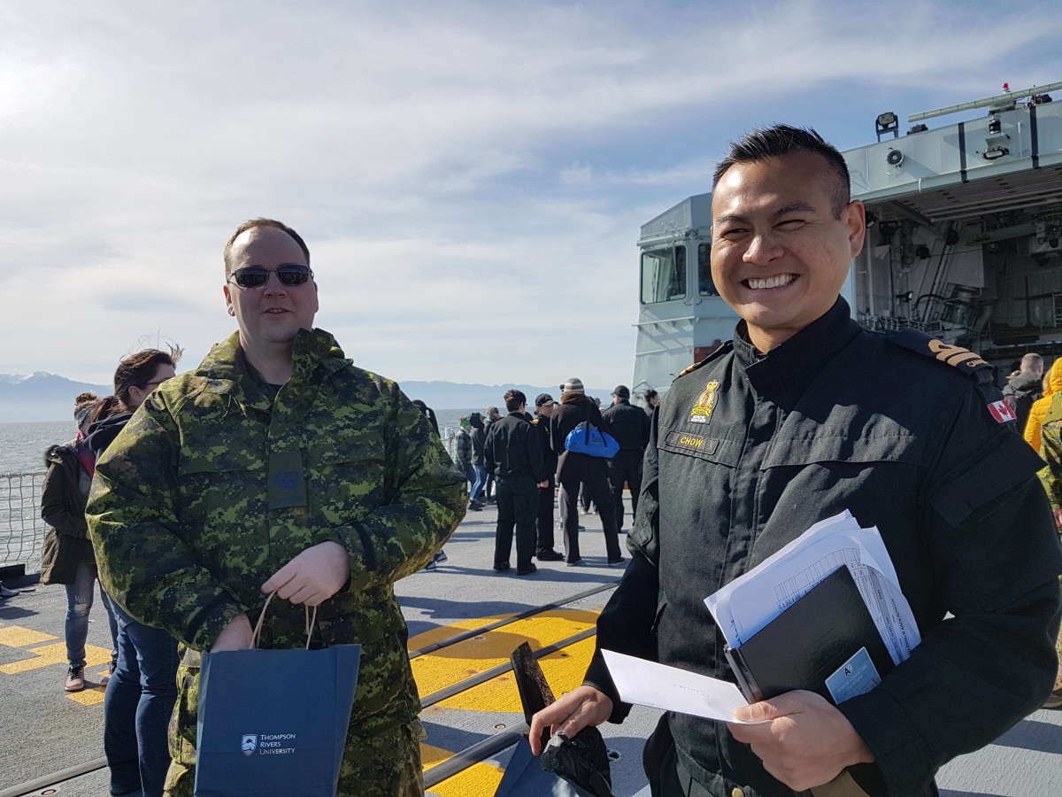 Warrant Officer Jeffrey Bateman and Lt. Simon Chow accepting TRU gifts as a thank you for the invitation on the HMCS Regina